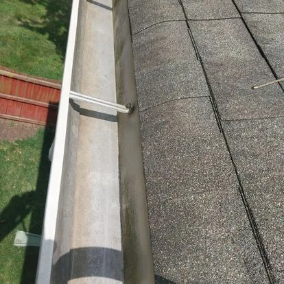 Close-up of a gutter and downspout being repaired